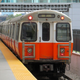 A photo of an Orange Line train pulling into a station in Boson.
